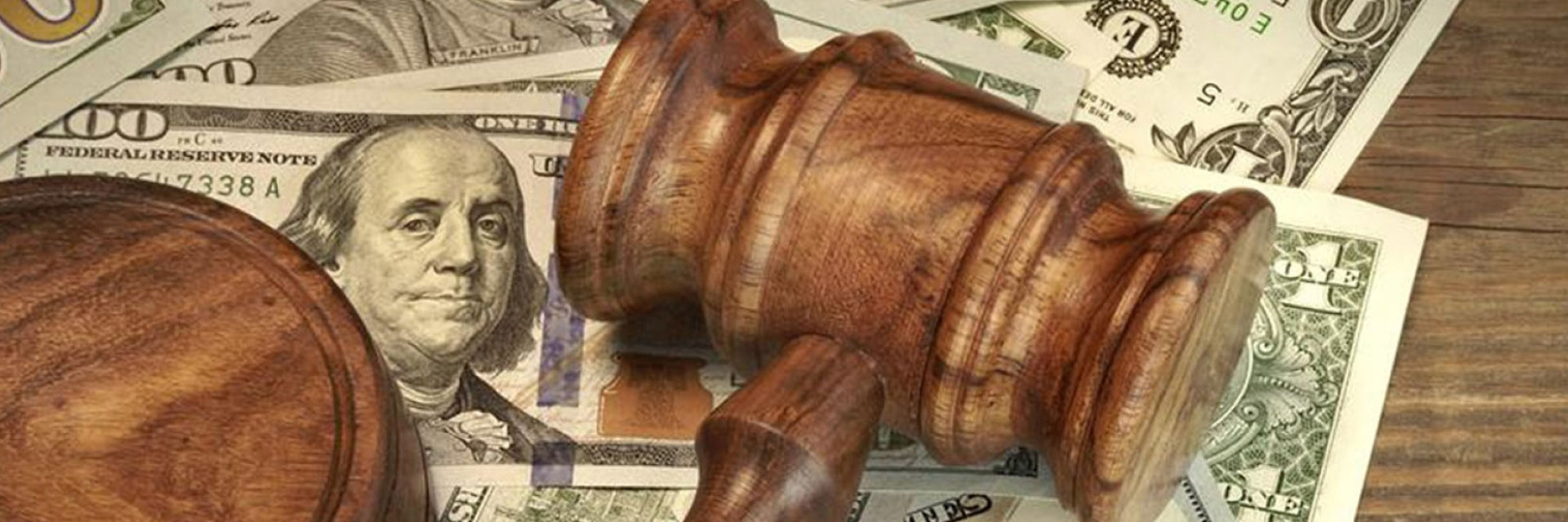 Image of a gavel over stacks of hundred dollar bills
